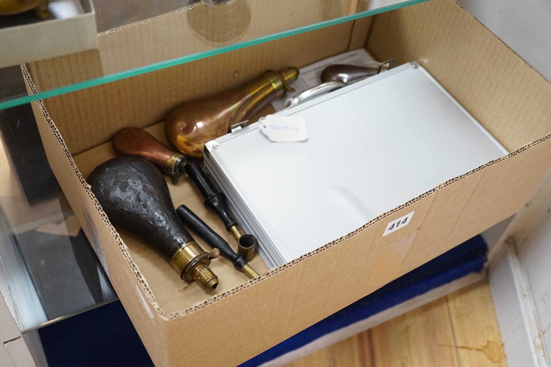Three copper powder flasks, a leather powder flask, two powder measures and two cases of cleaning tools